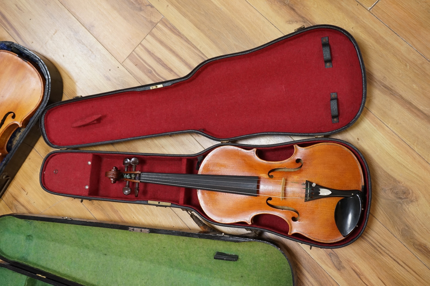 Three violins; a late 19th century German Stradivarius pattern violin, without label, a handmade violin (a.f.), with sound post crack, broken and repaired scroll, etc. and a Maidstone violin body, varnish stripped from t